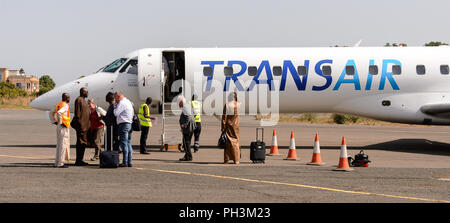 ZIGUINCHOR, SENEGAL - Apr 28, 2017: Unbekannter senegalesischen Fahrgäste stehen in der Nähe des Flugzeugs auf dem Flughafen von Ziguinchor im Senegal Stockfoto