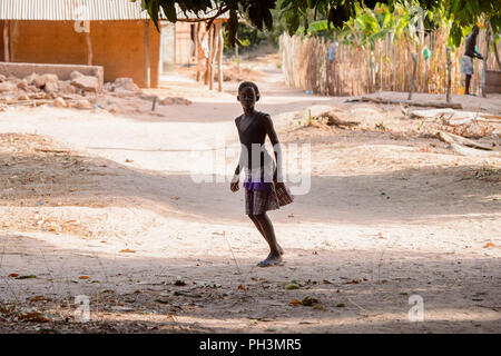 OUSSOUYE, SENEGAL - Apr 30, 2017: Unbekannter senegalesischen lockiges Mädchen steht in den Heiligen Wald in der Nähe von Kaguit Dorf Stockfoto