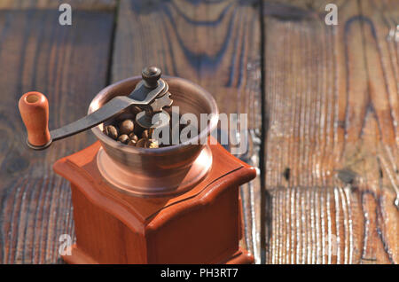 Kaffeemühle mit Kaffeebohnen auf Brettern, Textur, Hintergrund Stockfoto