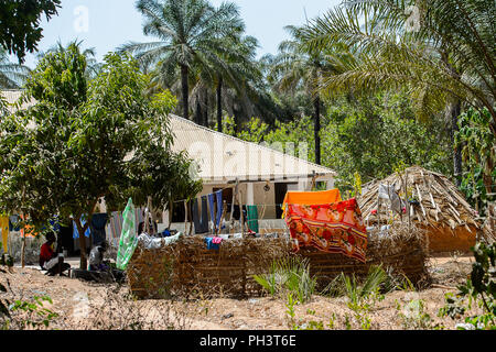 Straße nach Bissau, GUINEA B.-Mai 1, 2017: Unbekannter lokaler zwei Männer unter dem Baum sitzen in einem Dorf in Guinea Bissau. Immer noch viele Menschen im Land Stockfoto