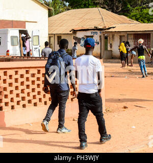 Straße nach Bissau, GUINEA B.-Mai 1, 2017: Unbekannter lokaler zwei Jungen zu Fuß von hinten in einem Dorf in Guinea Bissau. Immer noch viele Menschen im Land Stockfoto