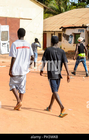 Straße nach Bissau, GUINEA B.-Mai 1, 2017: Unbekannter lokaler zwei Jungen zu Fuß von hinten in einem Dorf in Guinea Bissau. Immer noch viele Menschen im Land Stockfoto