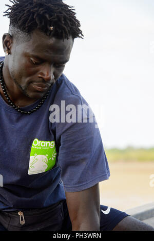 ORANGO INSEL, GUINEA BISSAU - Mai 3, 2017: Unbekannter lokaler Mann mit Zöpfen blickt auf der Insel Orango, Guinea Bissau Stockfoto