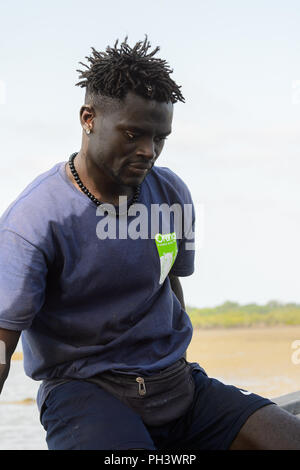 ORANGO INSEL, GUINEA BISSAU - Mai 3, 2017: Unbekannter lokaler Mann mit Zöpfen blickt auf der Insel Orango, Guinea Bissau Stockfoto