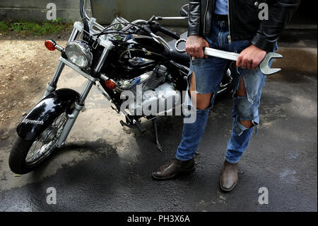 Motorradfahrer, Reparatur, Classic, Fahren, Häcksler, Freiheit, Schlüssel, Fahrzeug, Beine, Teil, jeans, Lifestyle, Werkstatt, Arbeit, Warten, Mann, auf der Straße, auf dem Weg, Stockfoto