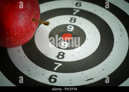 Konzeptionelle Bild eines mit Red Bulls Eye Center und einem frischen saftigen Red Apple auf die Oberseite in der Nähe zu sehen, platziert Stockfoto