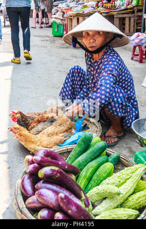 Hoi An, Vietnam - am 1. März 2010: Frau street Hersteller Verkauf von Hähnchen und Gemüse. Viele Güter sind atstreet Märkten verkauft. Stockfoto