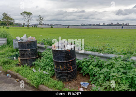 Brooklyn, NY - 20. August. 2018 Rest Stop auf den Belt Parkway suchen auf Coney Island mit überquellenden Mülltonnen zeigt die Auswirkungen auf die Umwelt. Stockfoto