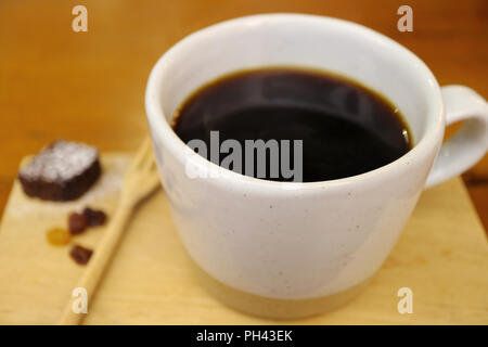 Heißer Schwarzer Kaffee in weisser Schale auf Holz- fach, selektiver Fokus und unscharfen Hintergrund Stockfoto