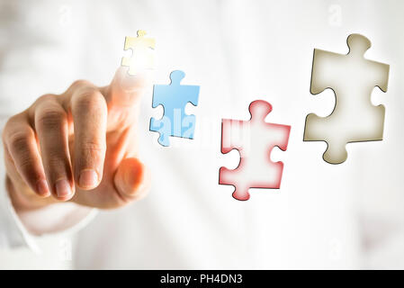 Konzeptionelle Bild des Unternehmens Vision und Plan mit Puzzleteilen in virtuellen Bildschirm mit Geschäftsmann Anordnen mit seinem Finger. Stockfoto