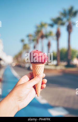 Woman's Hand Obst Eis in der Waffel Kegel. Stockfoto