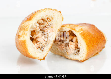 Leckere Blätterteig Dessert in zwei Hälften geschnitten. Köstliches Gebäck mit Hackfleisch Fisch auf hellen Hintergrund. Stockfoto