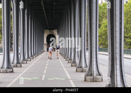 Zwei Männer auf skateboards Reiten entlang der Bir Hakeim Brücke in Paris, Frankreich. Stockfoto