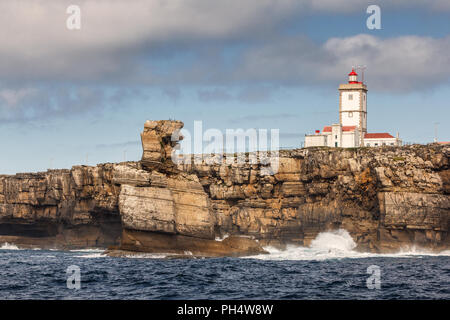 Felsformation Nau dos Corvos und Cape Carvoeiro Leuchtturm vom Meer aus gesehen am späten Nachmittag in der Nähe von Peniche in Portugal. Stockfoto