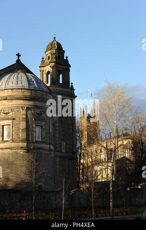 St. John's Church, in der Ferne - St. Cuthbert's Church im Vordergrund. Edinburgh, Schottland. Von den Princes Street Gardens aus gesehen am sonnigen Wintertag Stockfoto