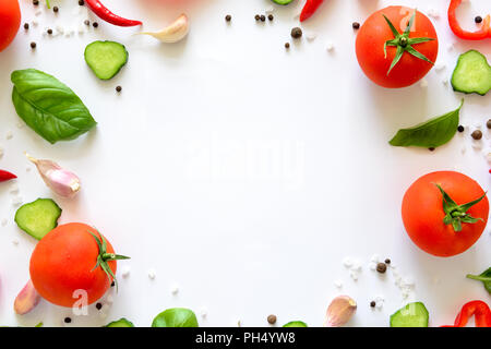 Bunter Salat Zutaten Muster aus Tomaten, Pfeffer, Chili, Knoblauch, Gurkenscheiben und Basilikum auf weißem Hintergrund. Kochen Konzept. Ansicht von oben Stockfoto