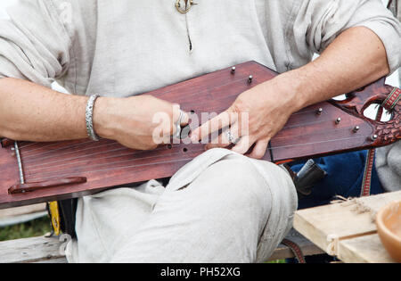 Man spielt die Harfe Sitzen im Freien. die Hände closeup Stockfoto