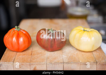 Heirloom Tomaten auf einer hölzernen Schneidebrett. Stockfoto