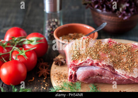 Rohe Schweinerippchen mit Gemüse auf einem Holztisch Stockfoto