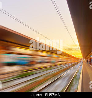 Perspektive der Plattformen von Bahnhof bei Sonnenuntergang in der Motion Blur - Zusammenfassung Hintergrund Stockfoto