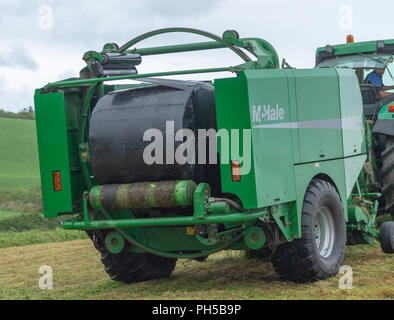 McHale Pressen Pressen von Silage in schwarze Plastikfolie auf einem Bauernhof in Irland Stockfoto