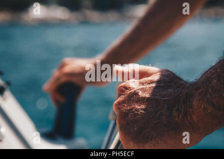 Nahaufnahme der Hand des älteren Kapitän am Lenkrad von Motorboot Stockfoto