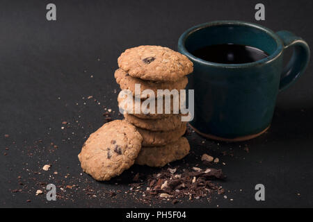 Hausgemachte Kekse, serviert mit einem Glas schwarzen Kaffee Stockfoto