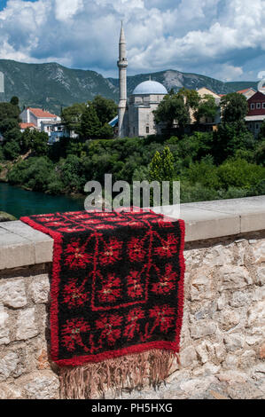 Bosnien, Europa: Skyline der Stadt Mostar, die Stadt der Stari Most (Alte Brücke), mit einem verzierten Teppich auf eine Mauer aus Stein und die Koski Mehmed Pascha Moschee Stockfoto