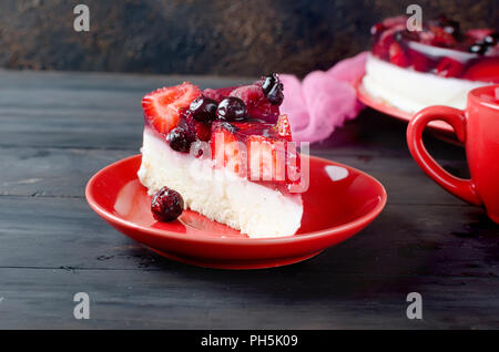 Stück Kuchen oder Käsekuchen mit frischen Beeren - Erdbeeren und Himbeeren zum Frühstück mit einer Tasse starken Kaffee, kopieren Raum Stockfoto