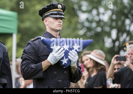 Ein Soldat aus der US-Armee Ehrengarde trägt eine US-Flagge während der vollen Ehren Gruppe Trauerfeier für US-Army Air Forces Flieger fehlt aus dem Zweiten Weltkrieg in Abschnitt 60 von Arlington National Cemetery, Arlington, Virginia, 27. Juni 2018. Der Rest waren die Flieger Tech. Sgt. John Brady; Tech. Sgt. Allen Candler, Jr.; 1. Lt John Liekhus; Staff Sgt. Robert Schuster; und Staff Sgt. Bobby Jünger. Alle fünf Flieger waren Mitglieder der 323 Bombardierung Squadron, 91st Bombardement Group (Heavy), Eighth Air Force, im Zweiten Weltkrieg, als ihre neun - Mann Bordpersonal war auf einer Mission zu Merseburg Stockfoto