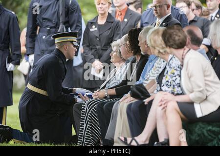 Us-Armee Kapitän Lukas Findley, Executive Officer, Charlie Company, 1.Bataillon, das 3D-US-Infanterie Regiment (Die Alte Garde), präsentiert die US-Flagge zu einem Familienmitglied während der vollen Ehren Gruppe Trauerfeier für US-Army Air Forces Flieger fehlt aus dem Zweiten Weltkrieg in Abschnitt 60 von Arlington National Cemetery, Arlington, Virginia, 27. Juni 2018. Der Rest waren die Flieger Tech. Sgt. John Brady; Tech. Sgt. Allen Chandler, Jr.; 1. Lt John Liekhus; Staff Sgt. Robert Schuster; und Staff Sgt. Bobby Jünger. Die Flagge ist Nancy Farrell, Schwester Schuhmacher. Alle fünf Flieger waren mir Stockfoto