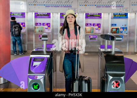 Zu Fuß durch die automatische ticket Barriere. asiatische Frau, die ihr Hab und Gut. Stockfoto