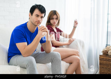 Frustriert Mann Mann sitzt neben seiner Frau, wenn sie in der Schwangerschaft Test in der Frau die Hand. Keine gute Nachrichten am Morgen Stockfoto