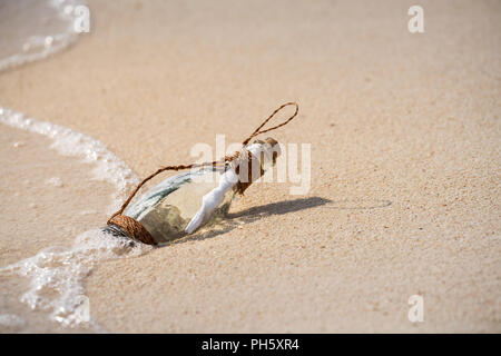 Schreiben Nachricht in einem Glas transparent Flasche auf dem Strand, Konzept für die Kommunikation. Stockfoto