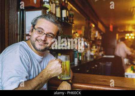 Gerne schöner Mann Holdin von Bier im Pub Stockfoto