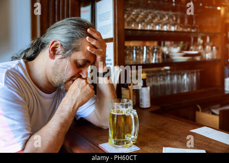 Mittleres Alter Mann trinkt Bier, lächelnden Mann mit Stockfoto