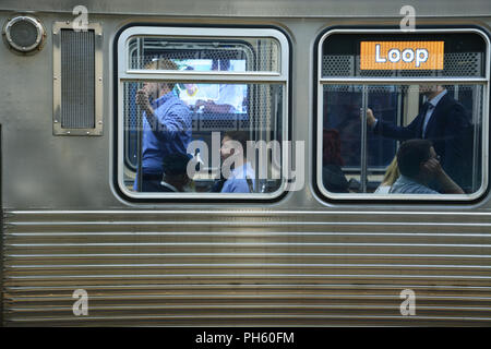 Pendler nehmen einem überfüllten El Zug in die Schleife auf Chicagos erhöhten braune Linie zu arbeiten. Stockfoto