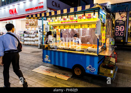 Suwon, Südkorea - 14. Juni 2017: Frau Verkäufer warten auf Käufer in ihrer fast food Kiosk an der Hauptstraße in Suwon. Stockfoto