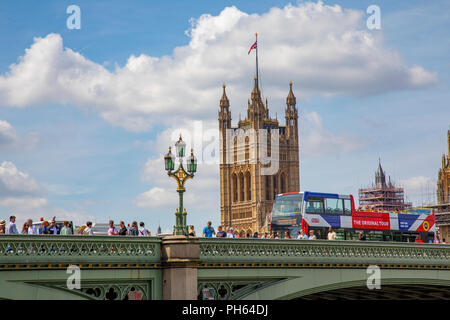 Klassik Doppel Decker Tour bus in London England überqueren der Brücke die Themse mit dem Parlament Haus im Hintergrund Stockfoto