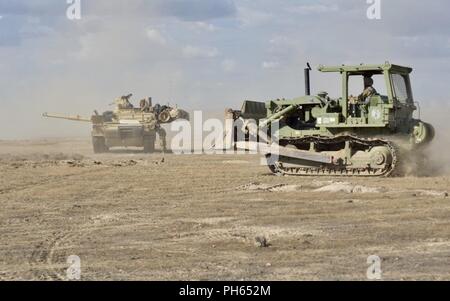 Ein Ingenieur von einem Unternehmen, 116 Brigade Engineer Battalion fahren Sie an einem M1A2 Abrams Kampfpanzer kämpfen Positionen für die Oklahoma Army National Guard, 3-116 th kombinierte Waffen Bataillon Juni 20, 2018, während der die 116 Kavallerie Brigade Combat Team exportierbar Kampftraining Fähigkeit Rotation an der Orchard Combat Training Center zu errichten. T Stockfoto