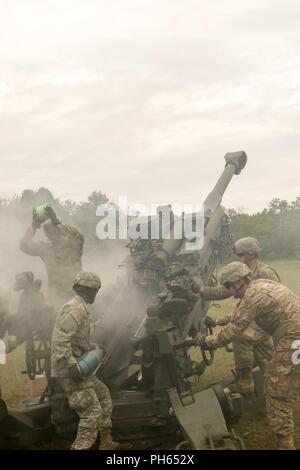 A Gun Crew mit Batterie C, 1.BATAILLON, 134 Field Artillery Regiment lädt eine M777 Haubitze in zwischen Volleys während einer Live-fire Übung Juni 24, 2018, während das jährliche Training im Camp Äsche gemeinsame Manöver Training Center in Grayling, Mich. Batterie C ist Fielding neue Haubitzen, die 155 mm M 777, einen Übergang für diese Soldaten, die Kommen von den kleineren 105-mm-Haubitze M119. (Ohio National Guard Stockfoto