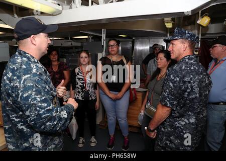 NORFOLK, Virginia (26. Juni 2018) - Aviation Electronics Technician 1. Klasse Charles Fletcher, links, von Jacksonville, Florida, bietet eine Besichtigung der USS Gerald R. Ford's (CVN 78) Aviation intermediate Instandhaltungsabteilung Mitglieder der Naval Air Systeme Befehl in Patuxent River, Maryland bei einem Rundgang durch das Schiff. (Elemente dieses Fotos sind verschwommen aus Gründen der Sicherheit wurde.) Stockfoto