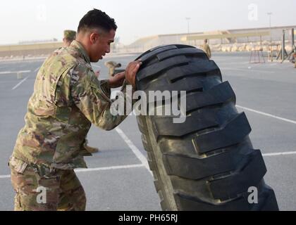 Us-Armee Sgt. Gary Cairns, ein Alpha Batterie" Sergeant, 5-52 Air Defense Artillery, spiegelt ein Reifen bei einem Hindernisparcours, Juni 18, 2018, Al Udeid Air Base, Katar. Das Hindernis Kurs war der zweite der drei körperlichen Herausforderungen Soldaten während einer vierteljährlichen besten Krieger Wettbewerb durchgeführt. Stockfoto