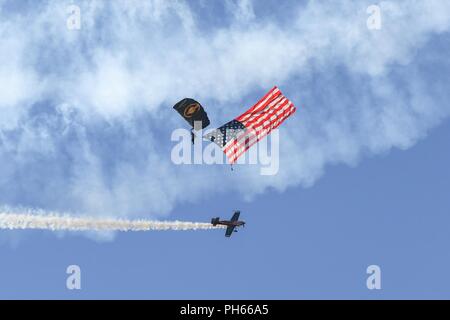 Ein U.S. Special Operations Command Der Para-Commandos Fallschirm demonstration Teammitglied führt eine Nationalhymne Flagge jum während der Krieger über den Wasatch Luft- und Raumfahrtmesse Juni 24, 2018, bei Hill Air Force Base in Utah. Die Para-Commandos bestehen aus dem aktiven Dienst spezielle Operatoren, wie Army Special Forces, Army Rangers, Navy SEALs, Air Force Combat Controller und Marine Räuber. Stockfoto