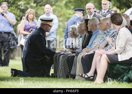 Us-Armee Oberstleutnant Jerry Farnsworth, Stabschef, Army National Soldatenfriedhöfe und Arlington National Cemetery; gibt sein Beileid zu einem Familienmitglied während der vollen Ehren Gruppe Trauerfeier für US-Army Air Forces Flieger fehlt aus dem Zweiten Weltkrieg in Abschnitt 60 von Arlington National Cemetery, Arlington, Virginia, 27. Juni 2018. Der Rest waren die Flieger Tech. Sgt. John Brady; Tech. Sgt. Allen Candler, Jr.; 1. Lt John Liekhus; Staff Sgt. Robert Schuster; und Staff Sgt. Bobby Jünger. Die anteilnahme ist Nancy Farrell, Schwester Schuhmacher. Alle fünf Flieger waren Mitglieder der Stockfoto