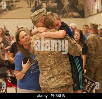 Ein Sohn vereint mit seinem Vater, wenn Soldaten mit der 1. Staffel, 180 Cavalry Regiment, 45th Infantry Brigade Combat Team, nach Hause kommen nach einer 8-monatigen Einsatz in Afghanistan im Rahmen einer Zeremonie in der Streitkräfte finden Zentrum in Norman, Oklahoma, Juni 26. Stockfoto