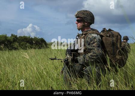 Cpl. Logan Loftis, eine Maschine gunner mit Fox Company, Bataillon Landung Team, 2nd Battalion, 5th Marines, und ein Eingeborener von Sheridon, Arkansas, bietet Sicherheit während eines simulierten Hubschrauber raid als Teil der 31 Marine Expeditionary Unit MEU Übung bei Ie Shima Ausbildungsstätte, Okinawa, Japan, 25. Juni 2018. MEUEX ist das erste in einer Reihe von vor der Bereitstellung Schulungen, die Vorbereitung der 31 Marine Expeditionary Unit in kürzester Zeit bereitstellen. Die 31. MEU, das Marine Corps' nur kontinuierlich vorwärts - bereitgestellt MEU, bietet eine flexible Kraft bereit, eine breite Palette von milita durchführen Stockfoto