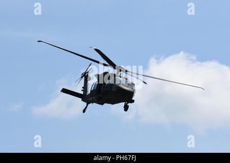 Ein UH-60 Black Hawk Hubschrauber auf das erste Bataillon des Wisconsin Army National Guard zugeordnet, 147 Aviation Regiment in Madison sucht die Lage eines simulierten Abgestürzten Piloten bei Hartholz Luft-Boden-Waffen in Central Wisconsin Juni 26, 2018, als Teil der 18 Die CSAREX "Suche und Rettung Übung. Die Mitglieder der 115. des Wisconsin National Guard Fighter Wing, 128. Air Control Squadron und 1 Bataillon, 147 Aviation Regiment trat Flieger zu 175 Flügel der Maryland Air National Guard bei Volk Feld Combat Readiness Training Center für die jährliche Übung entwickelt, Stockfoto