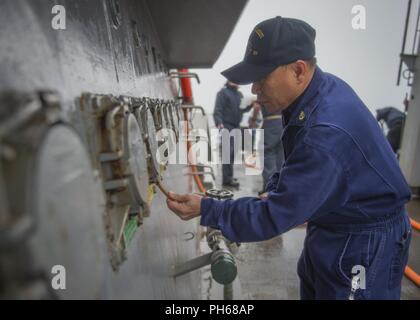 Norwegische See (23. Juni 2018) Chief Electrician's Mate Francisco Eraula, der Geführten zugeordnet Anti-raketen-Zerstörer USS Farragut (DDG99), Scrubs ein Schott, wie das Schiff führt ein frisches Wasser waschen. Farragut ist derzeit als Teil der Harry S. Truman Carrier Strike Group bereitgestellt. Mit USS Harry S. Truman (CVN 75) als Flaggschiff, bereitgestellt Streik Gruppe Einheiten gehören Personal, Schiffe und Flugzeuge von Carrier Strike Group Acht (CSG 8), Zerstörer Geschwaders zwei Acht (DESRON 28) und Carrier Air Wing (CVW-1); sowie die Sachsen-Klasse deutsche Fregatte FGS Hessen (F221). Stockfoto