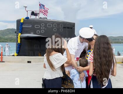 SANTA Rita, Guam (29. Juni 2018) Chief Elektronik Techniker Navigation Michael Levy erhält einen Kuss von Frau Crystal während ein homecoming Zeremonie auf der Pier für den Los-Angeles-Klasse schneller Angriff U-Boot USS Oklahoma City (SSN723), am 29. Juni. Oklahoma City ist eine von vier Vorwärts - Einsatz u-Boote zum Kommandanten, Submarine Squadron 15 zugewiesen. Stockfoto